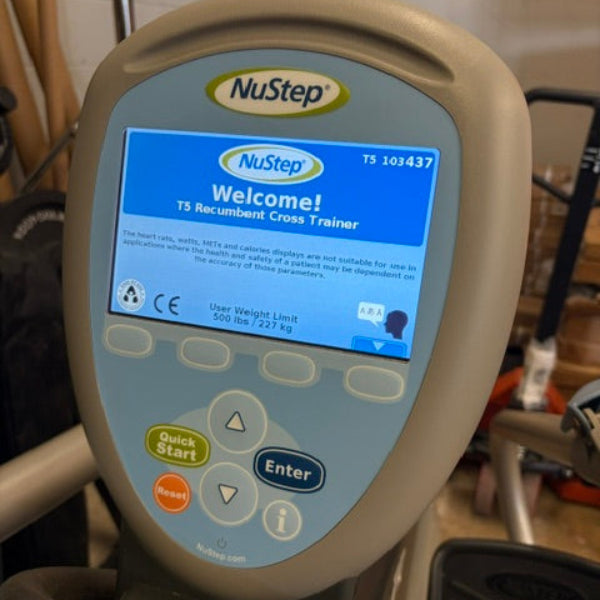 A close-up of a NuStep cross trainer console showing the welcome screen, with the brand logo visible at the top of the display.