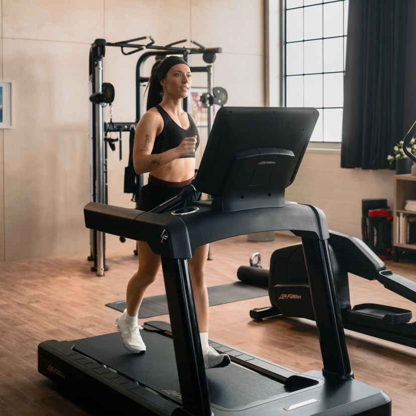 Woman exercising on a treadmill in a home gym setting