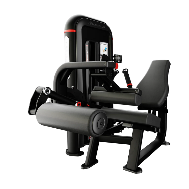 A black and gray leg extension gym machine with red accents, shown from a three-quarter angle on a solid white background.