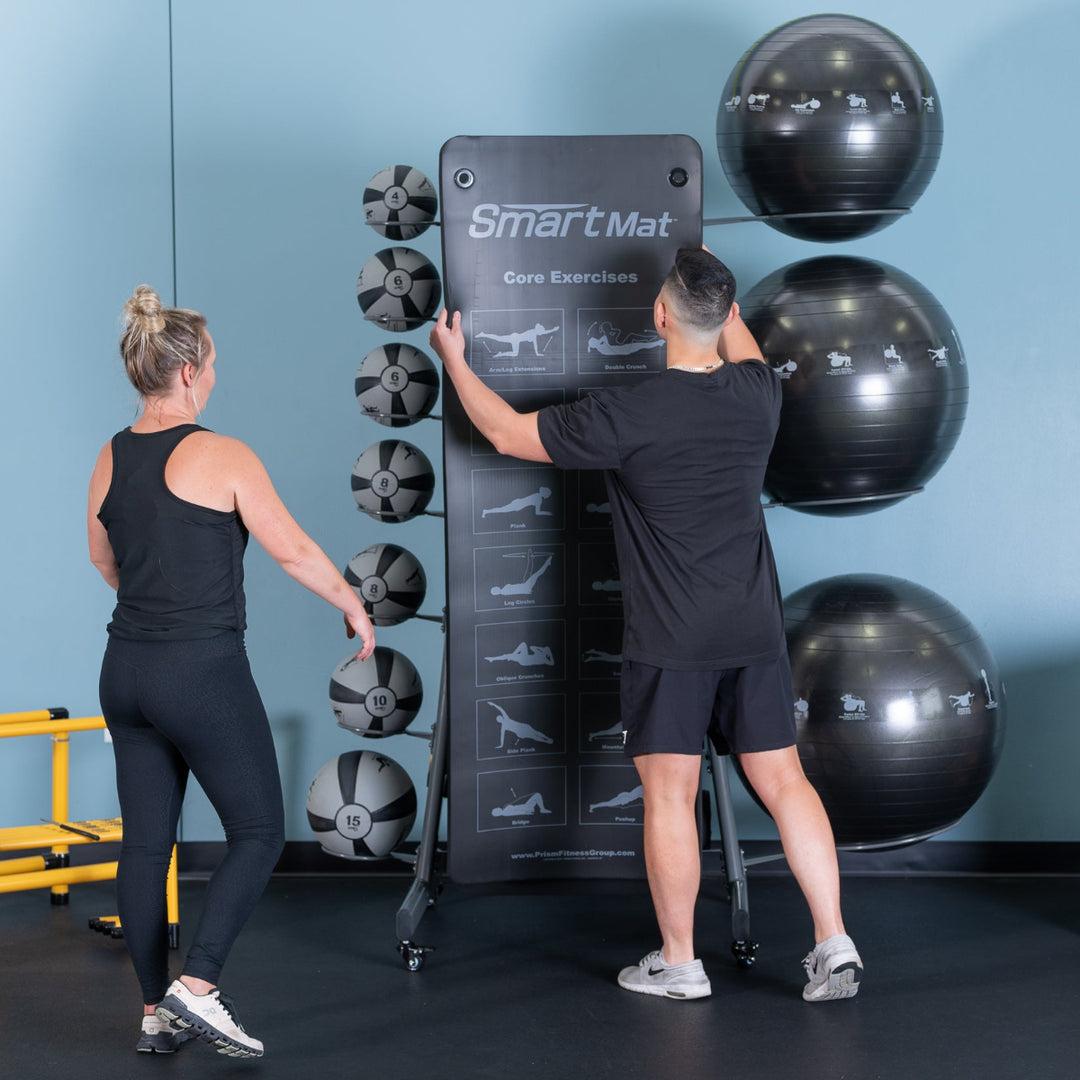 Two people using a SmartMat product in a gym setting with exercise balls and equipment.