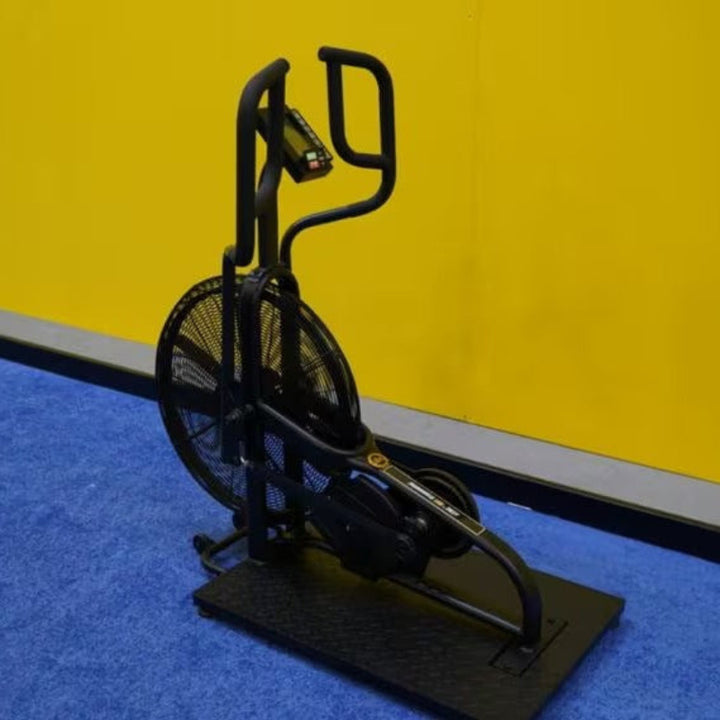 Black exercise bike model on a blue and yellow floor