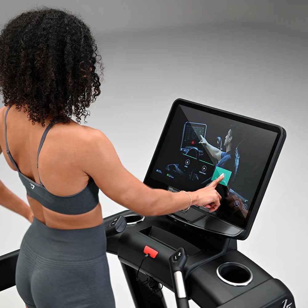 Woman using a treadmill with a touchscreen display