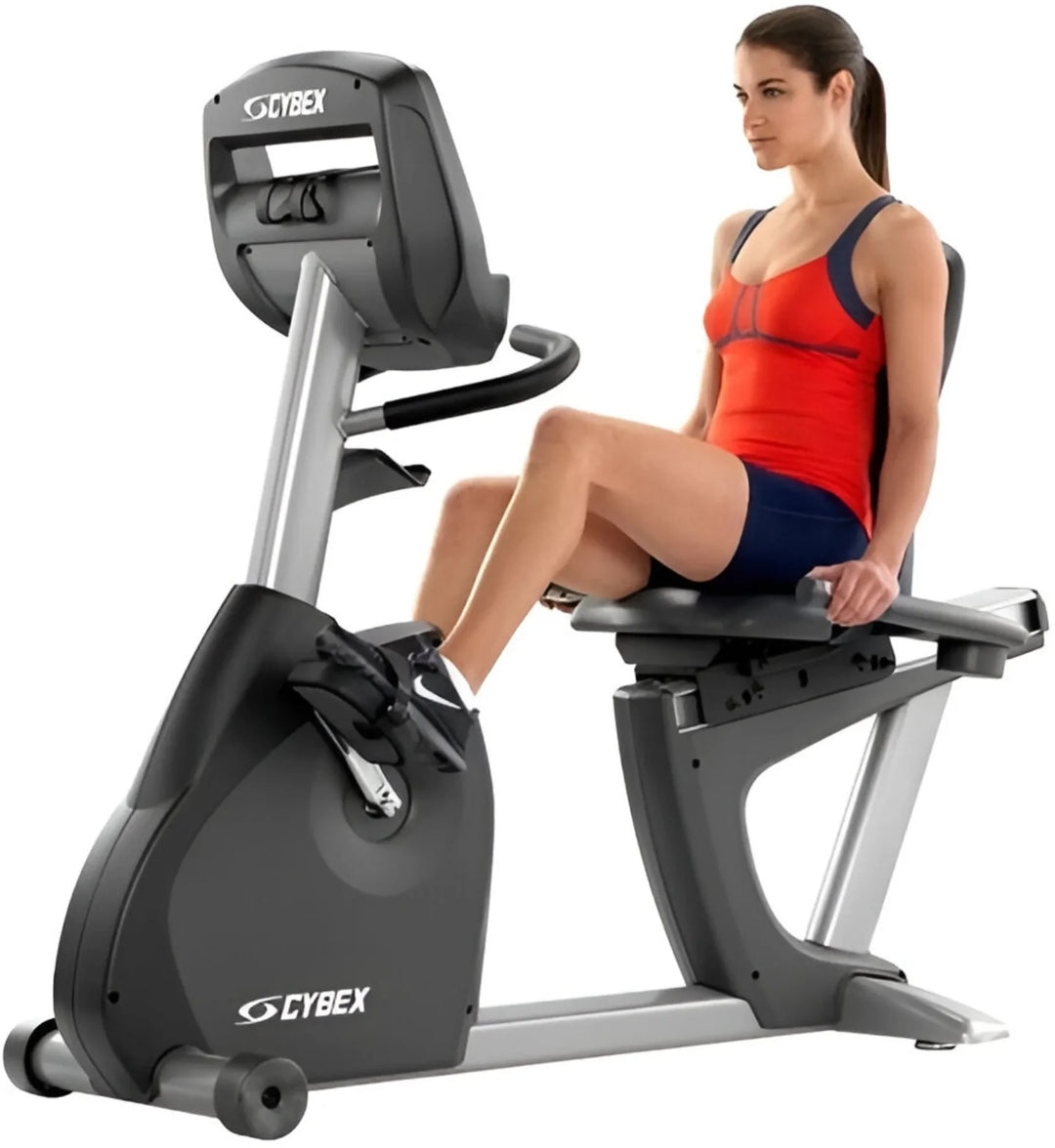 Woman exercising on a Cybex recumbent bike against a white background