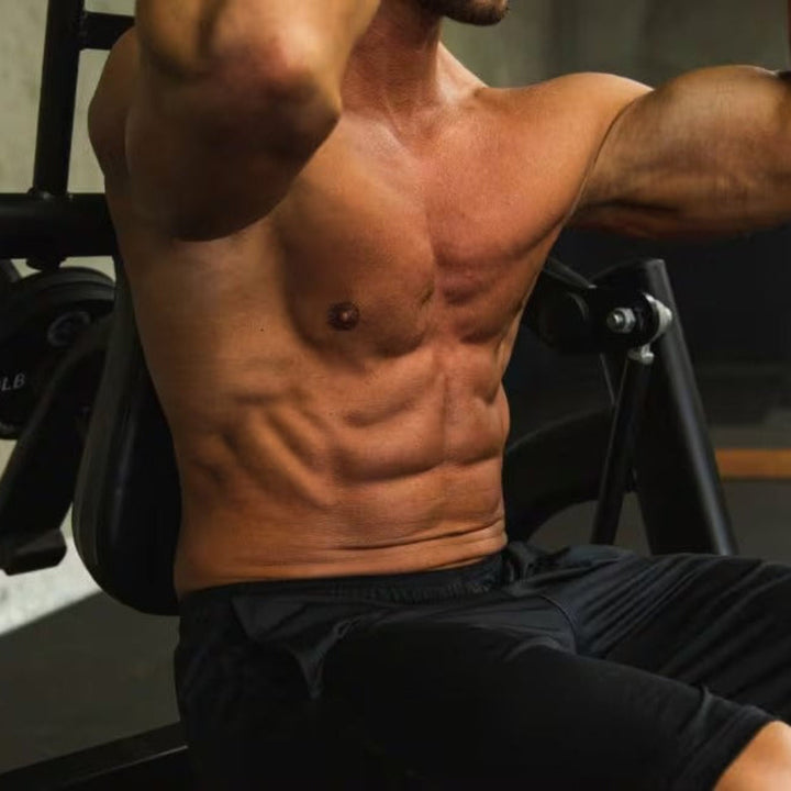 Man performing chest press exercise on a gym machine with a neutral background