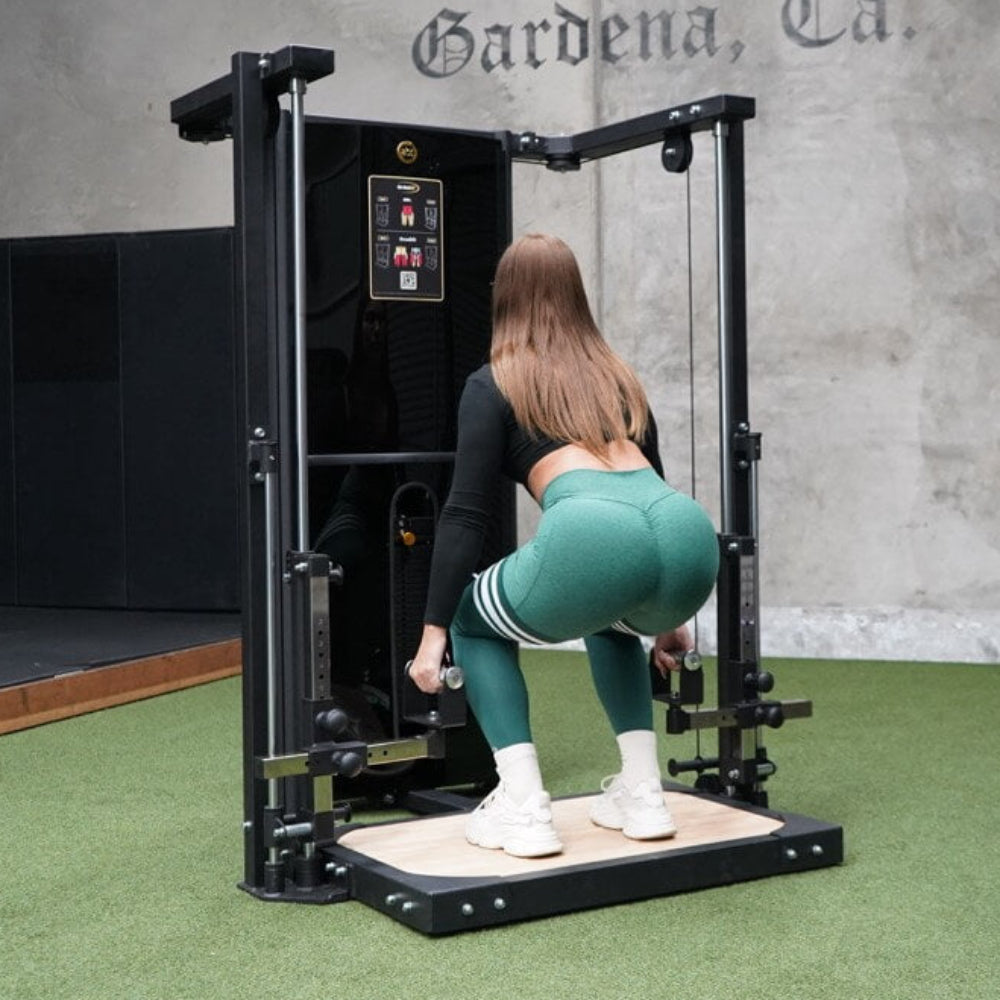 Person using a piece of exercise equipment in a gym setting with a concrete wall in the background.