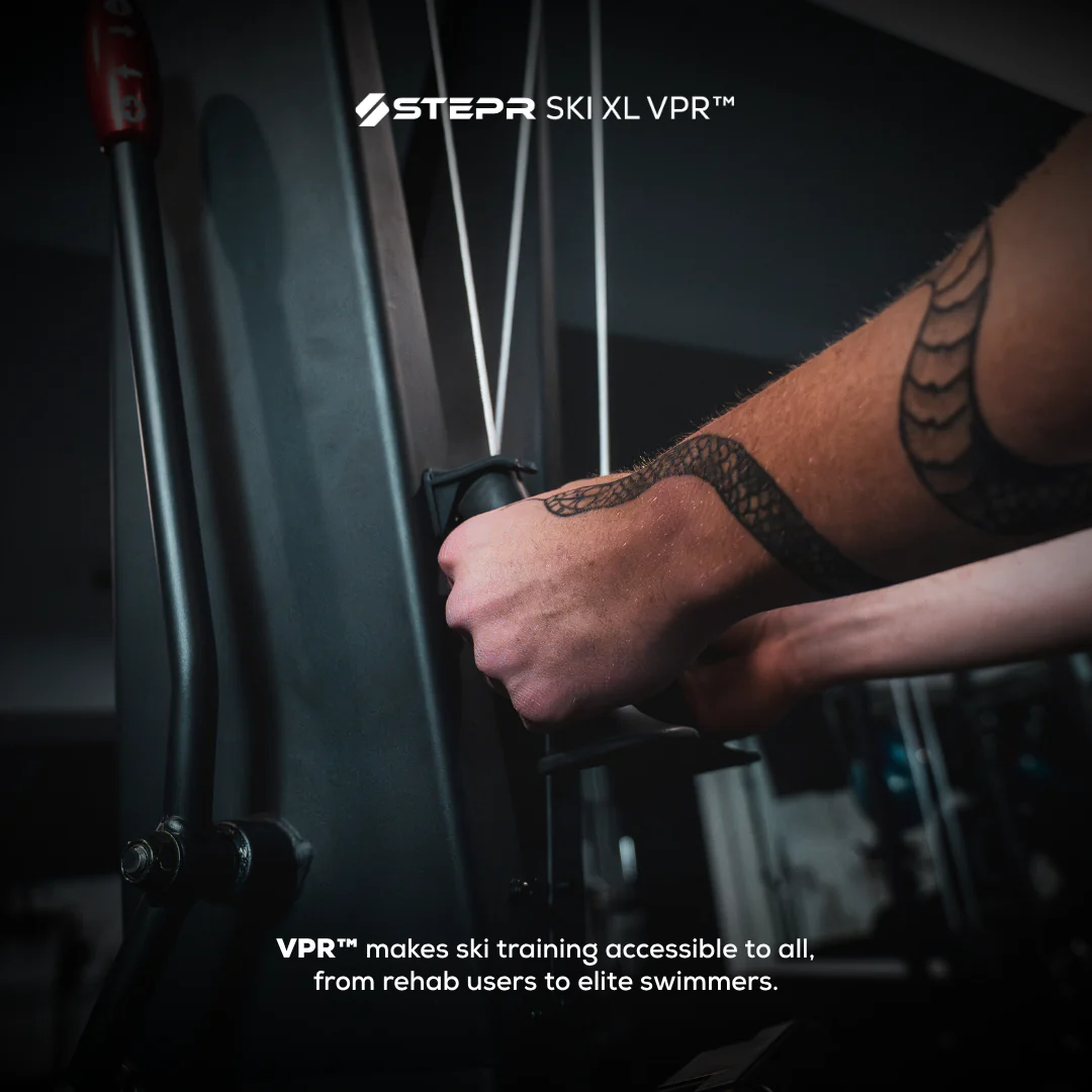 Person adjusting a ski with 'Stepr Ski XL VPR' branding, emphasizing accessibility in skiing training.