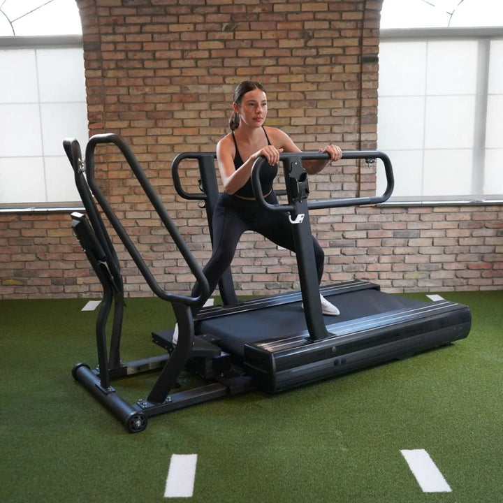 Woman exercising on a treadmill in an indoor setting with brick walls.